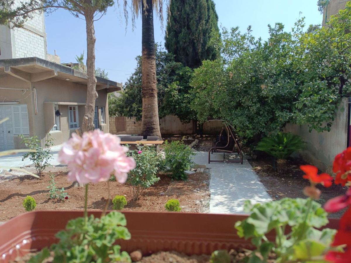 The garden of Al-Fusha Daraa, with tables and chairs under the trees